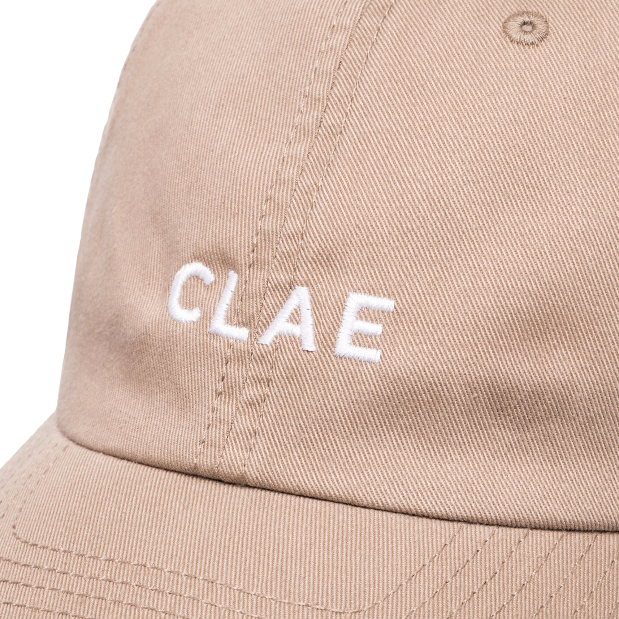 Close-up of white CLAE embroidery on khaki cotton dad hat